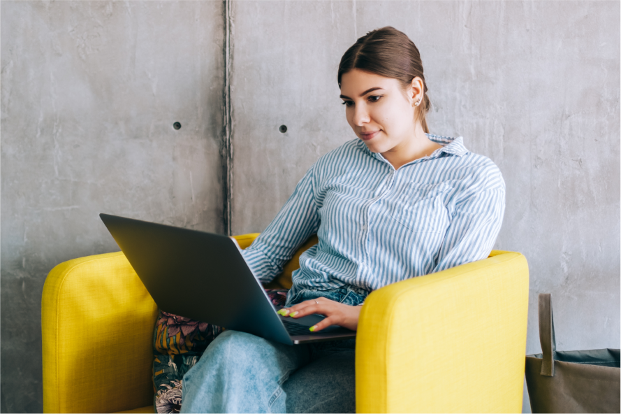 A person with a laptop in an office lounge chair