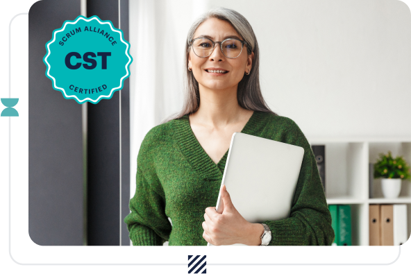 A woman wearing glasses and a green sweater holding a laptop.