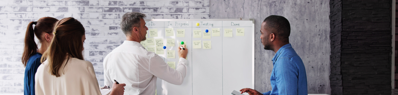 4 professionals collaborating at a whiteboard