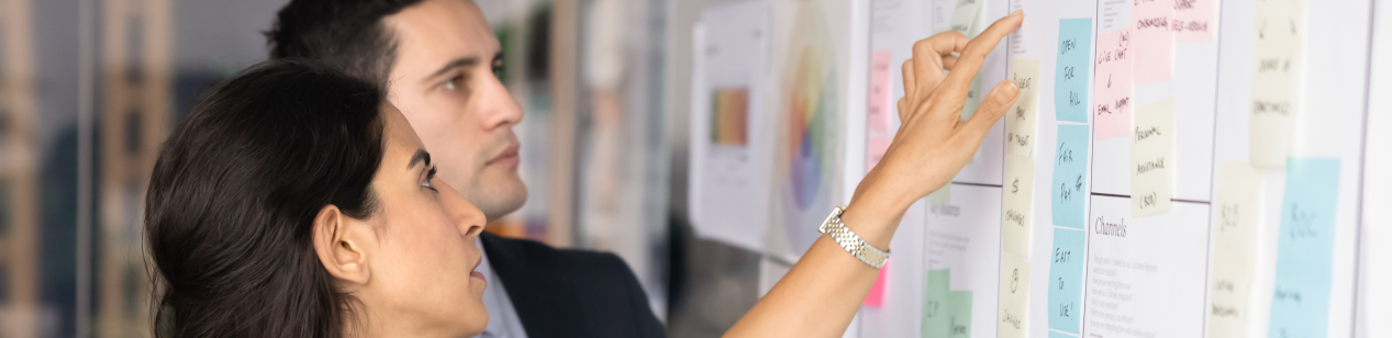 2 project managers collaborating at a whiteboard