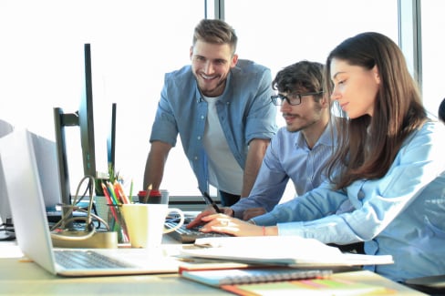 Colleagues working at a computer desk