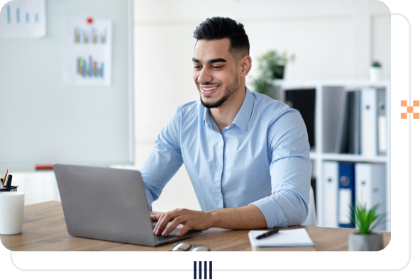 A businessperson smiling seated at a laptop