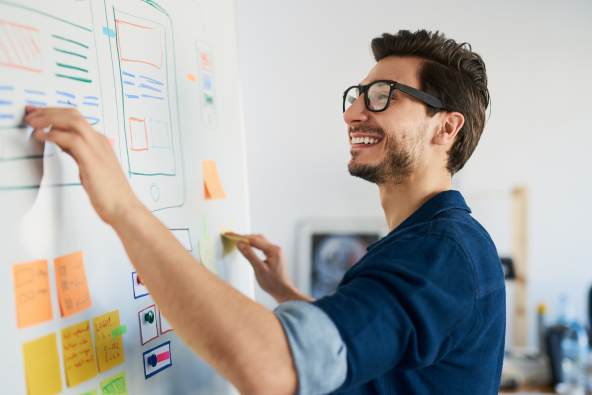 A man smiles while using a white board